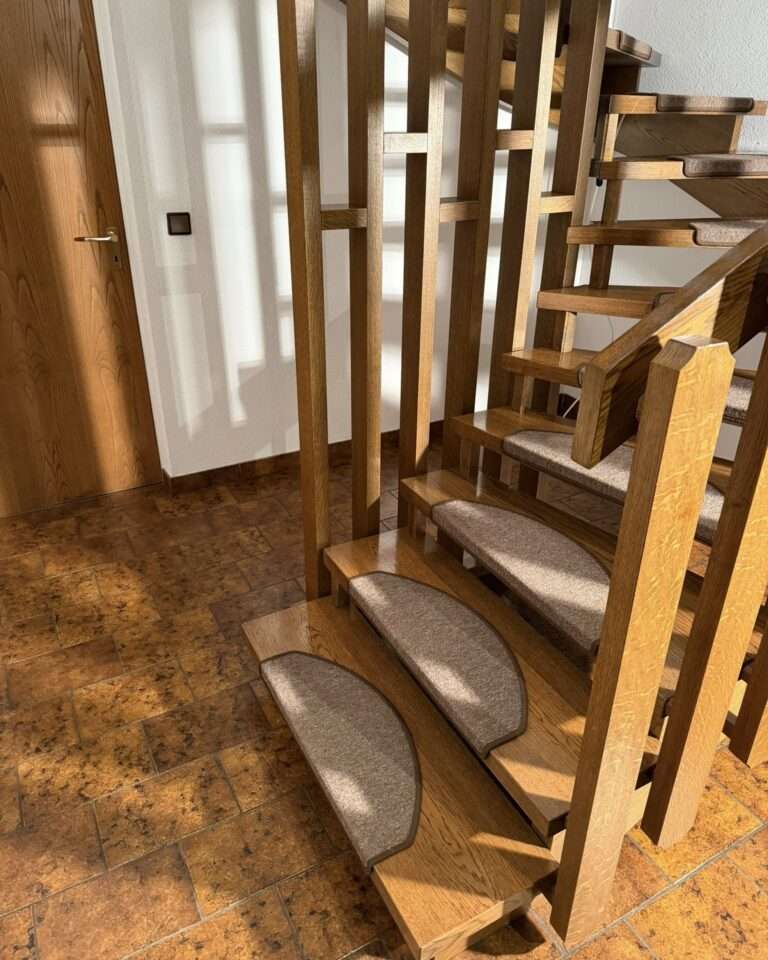 Projekte Die ersten Stufen der Holztreppe auf den Bodenfliesen, unter denen sich die Fußbodenheizung befindet.