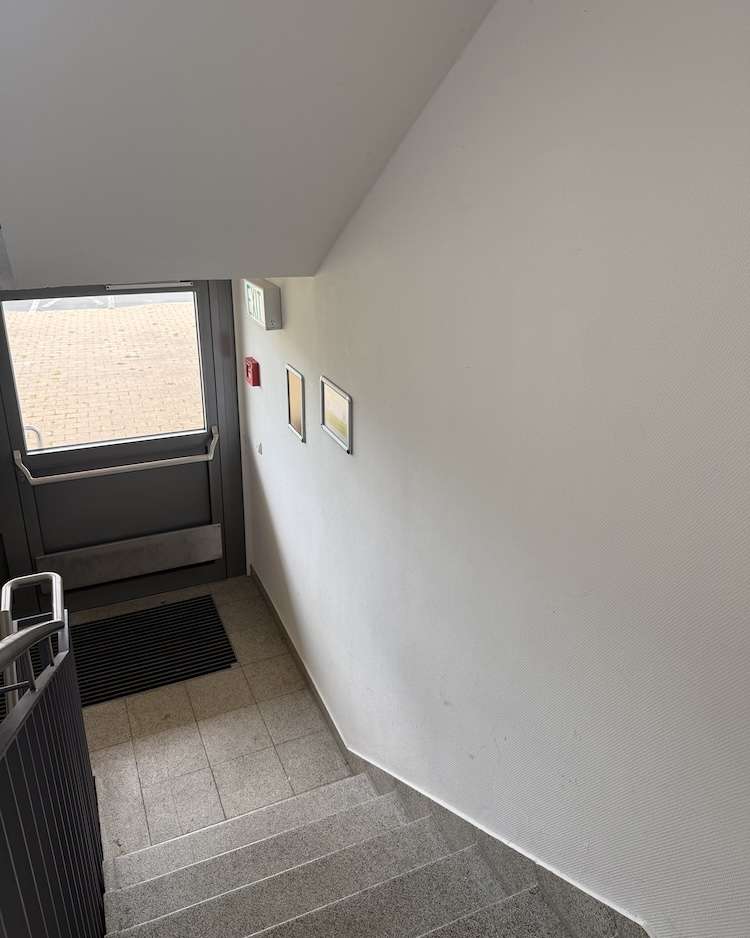 Projekte Blick von oben auf eine enge Granittreppe im Eingangsbereich vor dem Einbau des barrierefreien Plattformlifts in Illesheim.