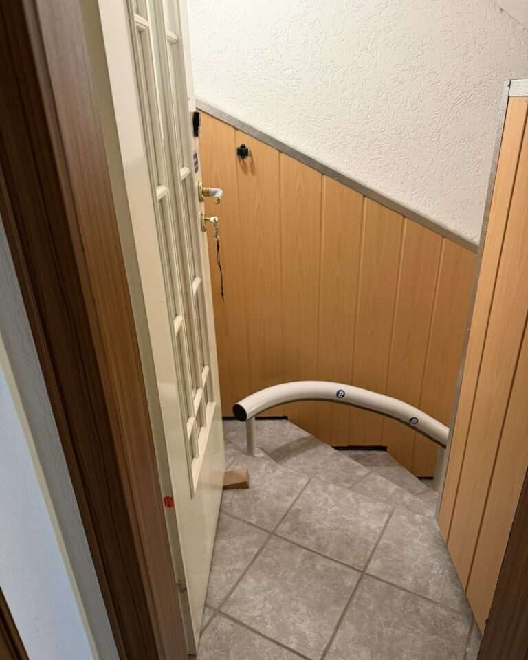 Projekte Blick von oben auf das Schienenende des Lifts und die geöffnete weiße Tür mit Holzkeil zur Veranschaulichung des Platzangebots.