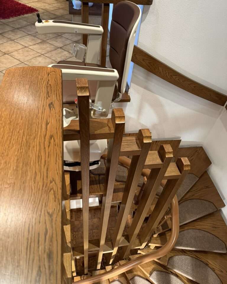 Projekte Blick auf den Schienenverlauf des Treppenlifts, der platzsparend an der Innenseite der Holztreppe montiert wurde.