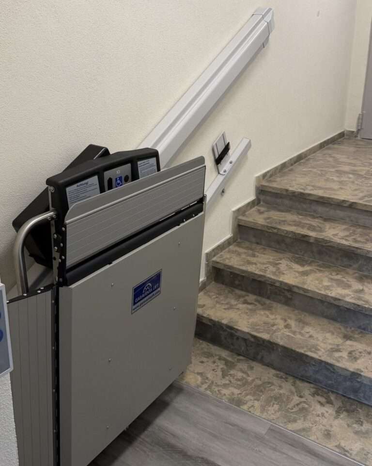 Projekte Detailansicht der Wandmontage eines Plattformlifts an einer Treppe im Rathaus Neusitz bei Rothenburg ob der Tauber.