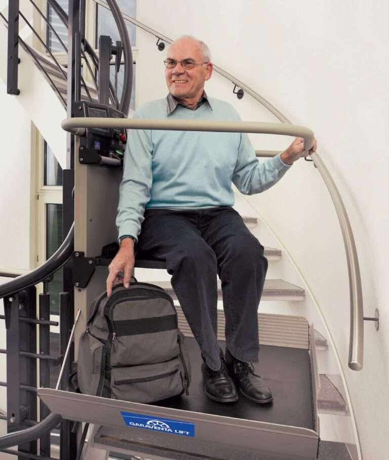 Senior nutzt einen kurvigen Plattformlift von Paitsch-Lifte mit integriertem Klappsitz an einer geschwungenen Innentreppe.