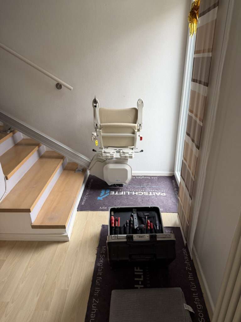 Fachgerecht montierter gerader Treppenlift von Paitsch-Lifte auf einer Holztreppe im Innenbereich.