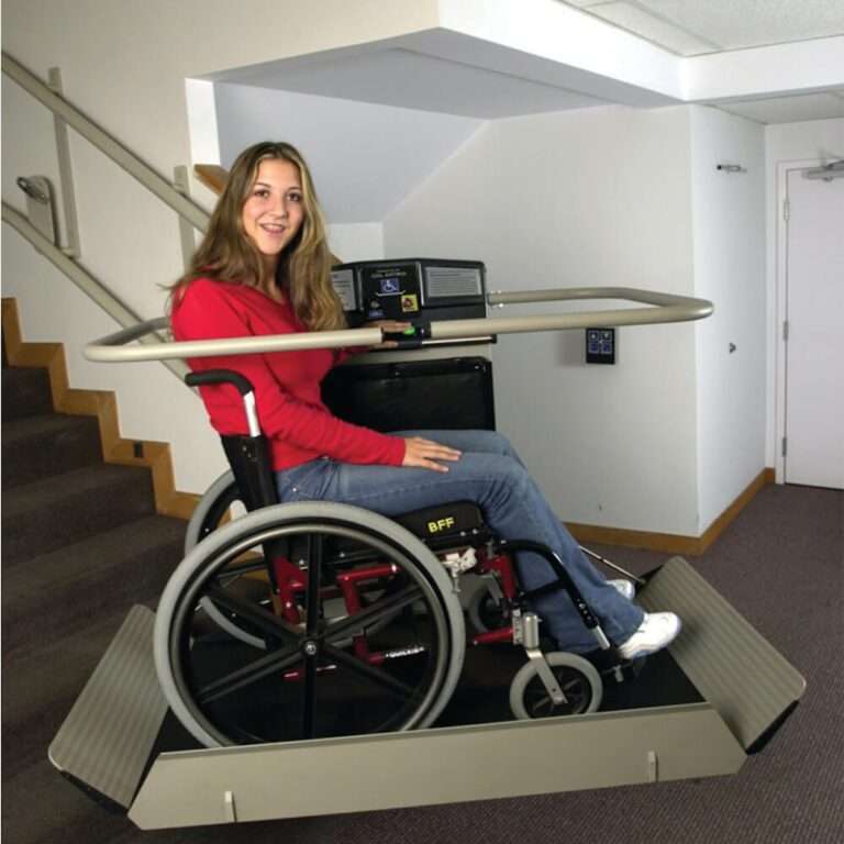 Eine Person nutzt einen Plattformlift von Paitsch-Lifte im Rollstuhl zur barrierefreien Überwindung einer Treppe im Innenbereich.